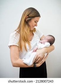 A Little White Caucasian Baby (boy) Just After Birth Sleeping Carried In His Mother's Arms. Intimate Family Moment. Maternal Love And Tenderness Concept.