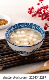 Little white tangyuan (tang yuan, glutinous rice dumpling balls) with sweet osmanthus honey and syrup soup in a bowl on wooden table background. - Shutterstock ID 2234342299