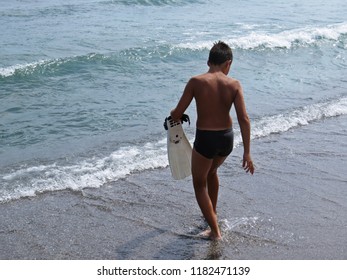 Little Young Boy On A Sand Beach In One Swimfin Flippers During Summer Vacation