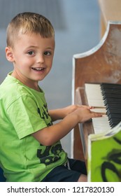 Little Young Caucasian Boy Playing On The Piano Outside Train Station