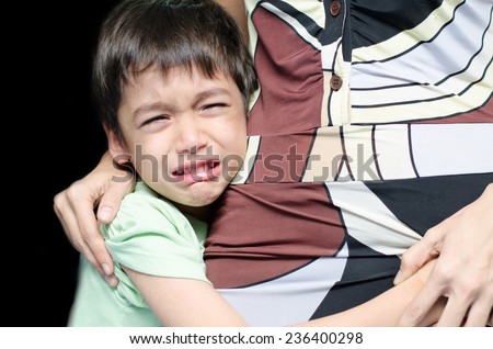 Littleboy crying holding his mother black background