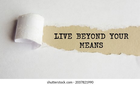 live beyond your means. words. text on grey paper on torn paper background. - Shutterstock ID 2037821990
