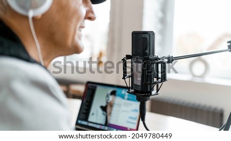 Live broadcast recording of the podcast show. A blogger on the radio communicates with listeners. A journalist and a laptop. The radio host transmits good news. The speaker speaks into the microphone.