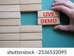 Live Demo symbol. Concept word Live Demo on wooden blocks. Beautiful grey green background. Businessman hand. Business and Live Demo concept. Copy space