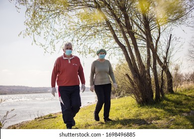 Live A Healthy Life. Senior Couple Walking Trough Nature With Mask On Face.