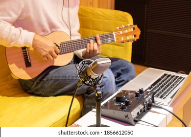 Live Music Streaming And Recording Concept. Music Vlogger Streaming A Live Video While Playing Acoustic Guitar In Home Studio