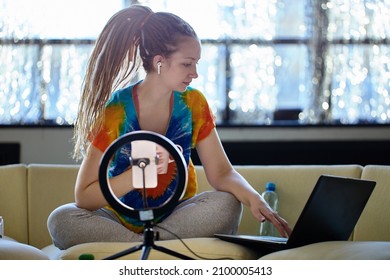 Live Streaming By Woman With Ring Light And Laptop On Sofa In Living Room.