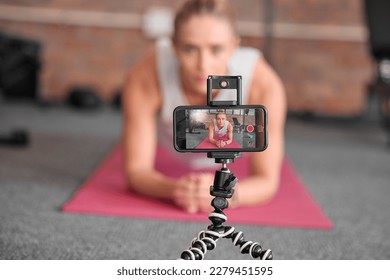 Live streaming, fitness and phone of woman exercise, pilates or workout on social media or video platform on tripod. Gen z athlete, sports influencer or content creator training on smartphone screen - Powered by Shutterstock