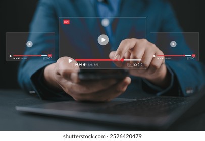 Live streaming and video content creation concept. A man uses a smartphone device with transparent video player interfaces, symbolizing live streaming, digital media, and video content creation.