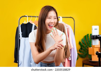 Live Streaming, Young Asian Woman Selling Clothes Online Using Smartphone Camera At Home.