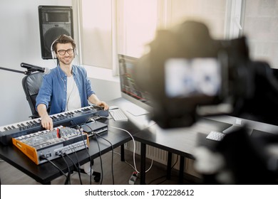 The Live Video Blogger Teaches How To Make Music Tracks Live. Video For Social Network Or Stream. DJ In Broadcasting Studio. Music Producer Is Composing A Song In Recording Studio.