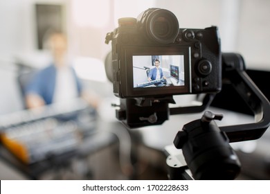 The live video blogger teaches how to make music tracks live. Video for social network or stream. DJ in broadcasting studio. music producer is composing a song in recording studio.