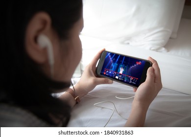 Live video streaming concept.Female holding mobile phone and wearing ear phone - Shutterstock ID 1840931863