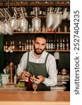 In a lively bar setting, a confident bartender mixes a fresh cocktail, showcasing his expertise with a bottle in hand, ready for the night