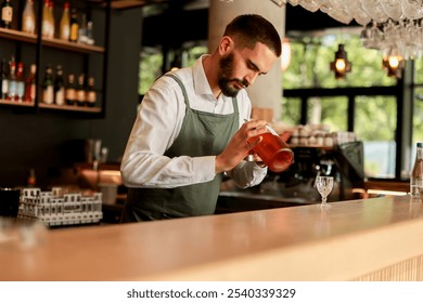 In a lively bar setting, a confident bartender mixes a fresh cocktail, showcasing his expertise with a bottle in hand, ready for the night's rush - Powered by Shutterstock