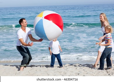 Lively Family Playing With A Ball At The Beach