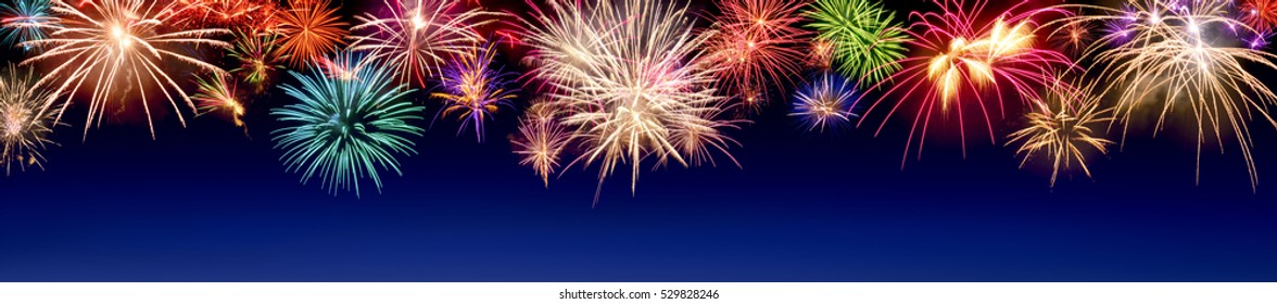 Lively multi-colored fireworks on dark blue background in panorama format, ideal for New Year or other celebration events - Shutterstock ID 529828246