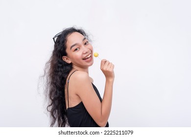 A lively and perky asian woman holding a lollipop. Isolated on a white background. - Shutterstock ID 2225211079