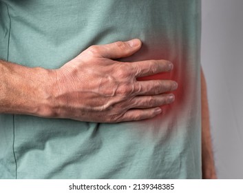 Liver Pain. Man Hand Holding Abdomen Right Side With Red Point Closeup. Diseases, Alcohol Abuse, Health Care, Treatment Concept. High Quality Photo