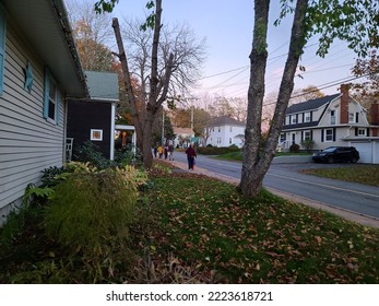 Liverpool, NS, CAN, October 31, 2022 - Halloween Trick Or Treaters Walking Down A Sidewalk On Halloween Night.