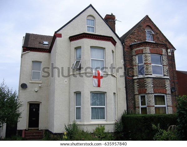 Liverpool UK - August 6 2006. Row house in\
England with England flag hanging out of\
window.