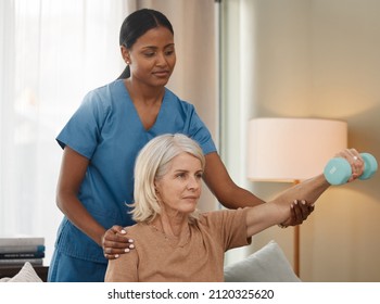 Living A Better Life With Each Lift. Shot Of A Senior Woman Using Dumbbells During An Exam With Her Doctor At Home.