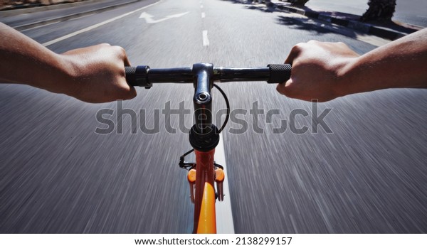 Living life behind bars. POV shot of a person\
riding a bicycle along a\
road.