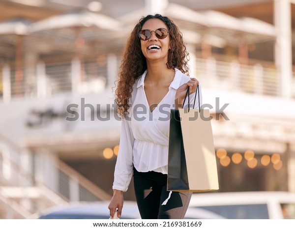 Living\
life in the designer lane. Shot of an attractive young woman\
walking alone outside while shopping in the\
city.