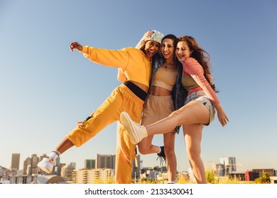 Living life to the fullest. Cheerful female youngsters smiling and having fun while standing together outdoors. Group of generation z friends making happy memories together. - Shutterstock ID 2133430041