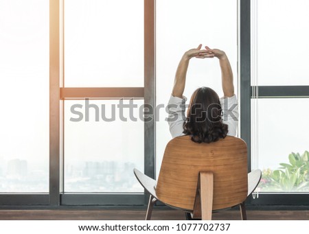 Living lifestyle, luxury simplicity home relaxation life style of happy working woman take it easy sitting resting on comfort chair at home, condominium or city hotel lobby interior with rooftop view