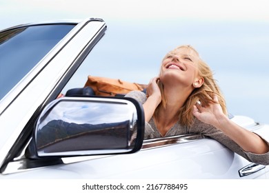 Living In The Moment. Shot Of A Young Couple Enjoying A Drive In A Convertible.