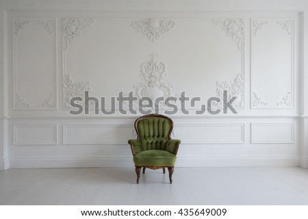 Living room with antique stylish green armchair on luxury white wall design bas-relief stucco mouldings roccoco elements