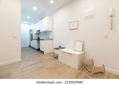 Living Room With Cabinet, Wicker Magazine Rack, Side Table And Hallway With White Kitchen With Gray Countertop In A Room With Oak Flooring