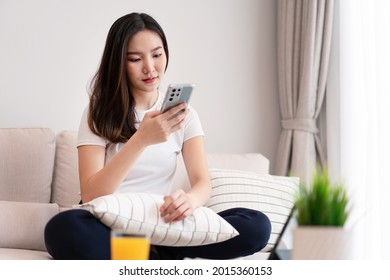 Living room concept a long-haired girl spending time on the electronic devices in the cozy room. - Shutterstock ID 2015360153
