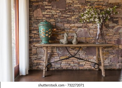 Living Room With Decorative Table, Stone Wall Behind.