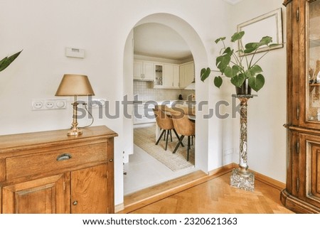 a living room with a dining table and an archway leading to the kitchen in the door is open on the right side