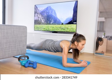 Living Room Fitness Workout - Girl Doing Plank Exercises To Exercise Core At Home. Young Asian Woman Training Muscles In Front Of The TV As Part Of A Healthy Lifestyle Without Going To The Gym.