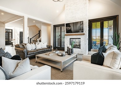 Living room interior beamed ceilings fireplace overstuffed leather sofa designer decor view to kitchen and dining room open concept luxury windows blue sky view to mountains autumn color chandelier