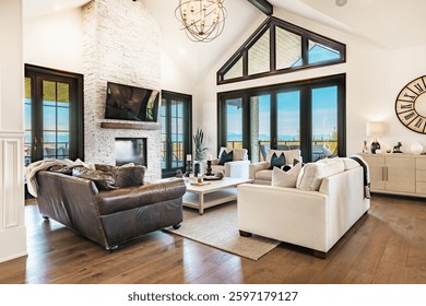 Living room interior beamed ceilings fireplace overstuffed leather sofa designer decor view to kitchen and dining room open concept luxury windows blue sky view to mountains autumn color chandelier