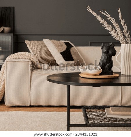 Living room interior with beige modular sofa, black coffee table, rug, pillows, plaid, vase with dried flowers, sculpture, trace, dark wall, lamp and personal accessories. Home decor. Template.