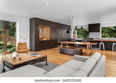 Living Room Interior And Kitchen In New Contemporary Style Luxury Home With Open Concept Floor Plan. Lights Are On.