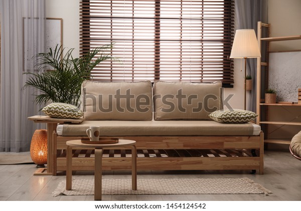 Living room interior with sofa, window blinds\
and stylish decor\
elements