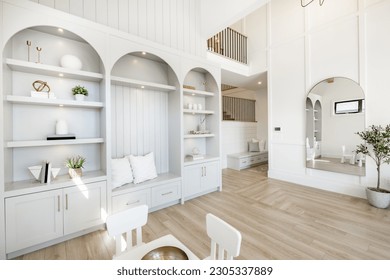 Living room interior with white decor arched mirror and built in shelving warm white tone minimalist - Shutterstock ID 2305337889