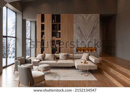 living room, marble wall fireplace and stylish bookcase to the ceiling in a chic expensive interior of a luxurious country house with a modern design with wood and led light, gray furniturу