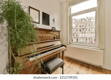 a living room with an old piano and some plants in the window simh is on the wall next to the piano