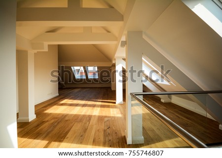 Living room on the rooftop floor, empty apartment with skylight windows and parquet flooring after renovation 