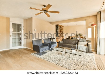 a living room with two couches and a ceiling fan in the room is very light brown, but it's not too