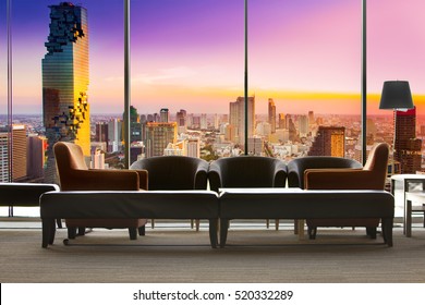 living room which can see cityscape at sunset, comfortable sofa unit in front of panoramic view windows overlooking the cityscape
