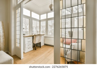 a living room with wood flooring and white shutters on the windows looking out onto an area with wooden floors