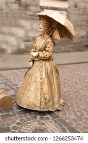 Living Sculpture. Golden Woman With Umbrella